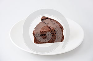 Piece of chocolate cake gateau chocola on a plate on white background