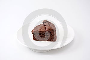 Piece of chocolate cake gateau chocola on a plate on white background