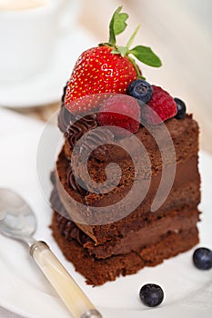 Piece of chocolate cake with icing and fresh berry