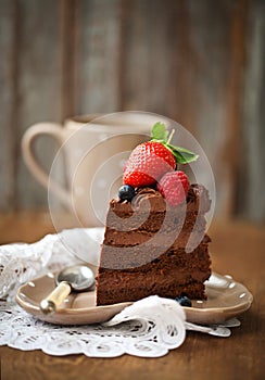 Piece of chocolate cake with icing and fresh berry