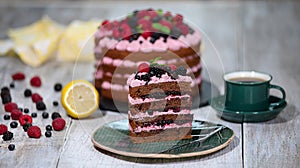Piece of chocolate cake with icing and fresh berry on wooden background