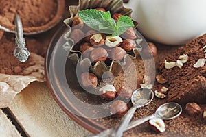 Piece of chocolate cake, mint leaves, hazelnuts and jar with milk