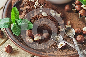Piece of chocolate cake, mint leaves, hazelnuts and jar with milk