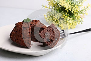 A piece of chocolate cake with mint on the table, close-up