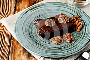 Piece of chocolate cake with nuts on green plate