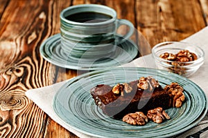 Piece of chocolate cake with nuts on green plate