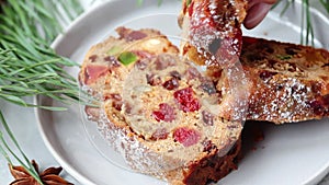 Piece of Christmas fruit cake on a plate in festive decorations