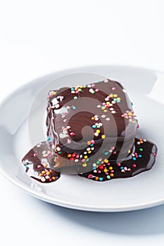 Piece of classic chocolate cake with colored sprinkles