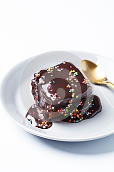 Piece of classic chocolate cake with colored sprinkles