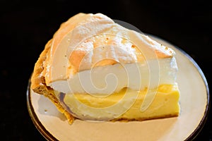 Piece of coconut meringue pie on white dish