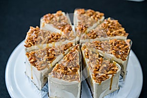 Piece of Coffee almond caramel cake on white plate in coffee shop on black background