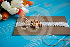 A piece of cotton lace with paper flowers and piece of brown paper