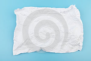 A piece of crumpled white paper on a blue background