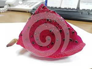 A piece of cut pitaya fruit(dragon fruit ) on the table