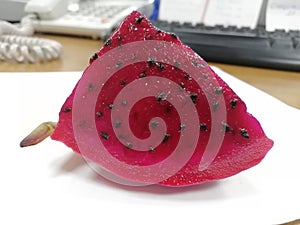 A piece of cut pitaya fruit(dragon fruit ) on the table