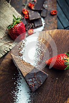 Piece of dark chocolate cake with strawberry. The restaurant or cafe atmosphere. Retro. Vintage