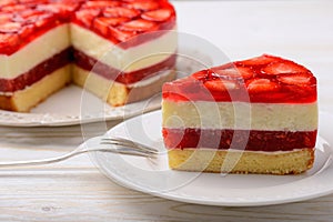 Piece of delicious cheesecake with strawberry mousse, strawberry jelly and strawberries.