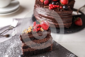 Piece of delicious chocolate cake with berries on slate plate