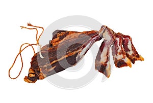 Piece of dried bacon with hanging rope and a few slices isolated on white background close up