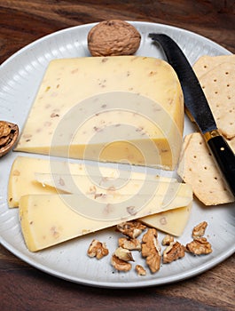 Piece of Dutch Gouda cheese made from cow milk with added walnuts close up