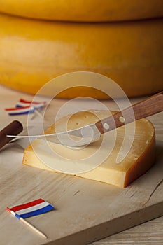 Piece of Dutch mature Gouda cheese on a cutting board