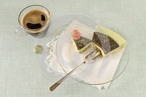 Piece of easter cake with tea matcha decorated chocolate ganache and sweet-stuff eggs on glass plate