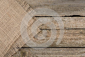 Piece of folded burlap fabric on wooden table, top view. Space for text