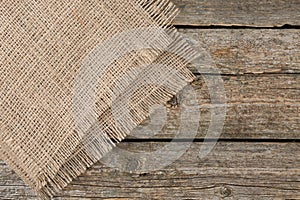 Piece of folded burlap fabric on wooden table, top view. Space for text