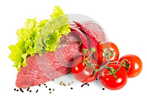 Piece of fresh veal, lettuce leaves, tomatoes and pepper isolated on white