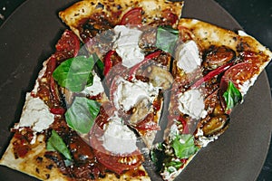 A piece of freshly baked homemade vegetarian pizza cuts with mussels tomatos tofu close up