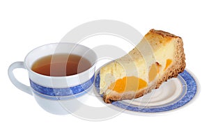 A piece of fruit cake on the saucer with a cup of tea isolated o