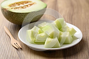 Piece of green melon fruit on plate