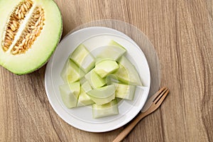 Piece of green melon fruit on plate ready to eating