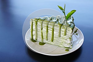 Piece of green tea crape cake on white plate