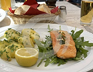 a piece of grilled fish and boiled potatoes with arugula