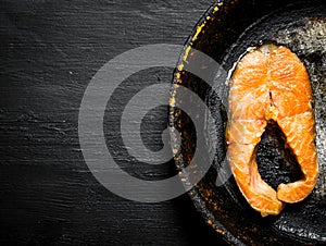 Piece of grilled salmon in an old pan.