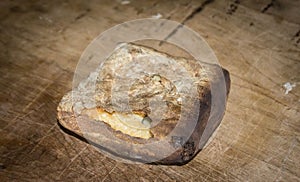 Piece of hardtack bread on wood surface.