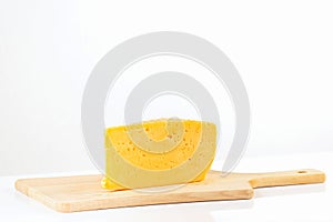 Piece of holland cheese on a wooden cutting board