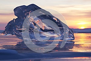 A piece of ice lying on the frozen surface of lake Baikal at dawn