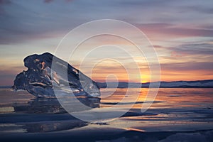 A piece of ice lying on the frozen surface of lake Baikal at dawn