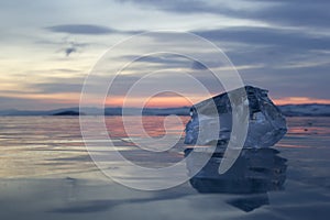 A piece of ice lying on the frozen surface of lake Baikal at dawn