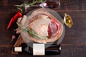 a piece of juicy, seasoned rib eye steak wrapped in paper and burlap on a cutting board on a wooden background