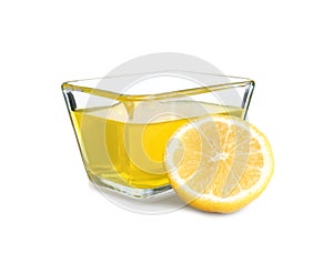 Piece of lemon and tasty jelly dessert in glass bowl on white