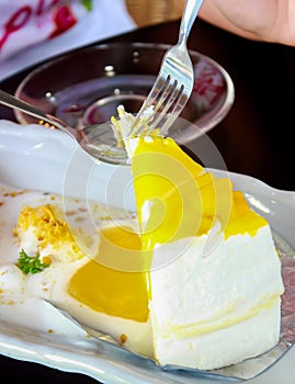 A piece of mango cheese cake on table wooden