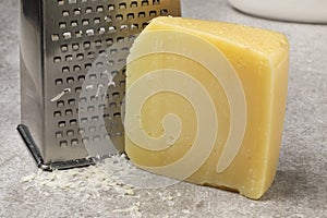 Piece of mature Italion Pecorino cheese and grater