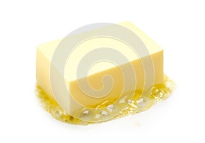 A piece of melting butter isolated