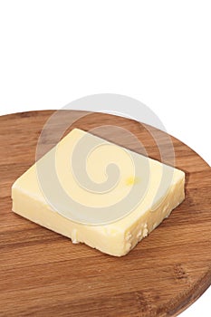 Piece of mozzarella cheese on a kitchen wooden board