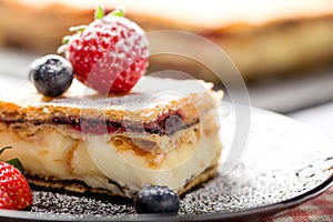 A piece of Napoleon cake with poppy seeds and cherries