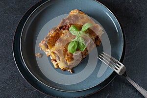 Piece of noodle casserole on a plate isolated on dark background