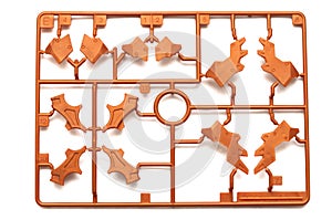 A piece of orange brown plastic scale model kit set with futuristic robotic parts